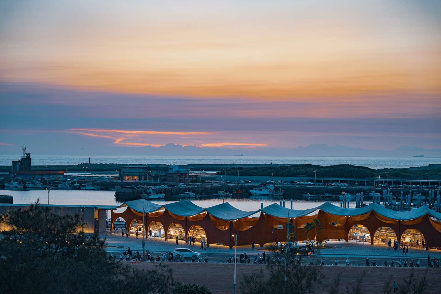 波光市集以波浪造型的透空式建築，坐落於南寮，黃昏時還能賞夕陽美景。